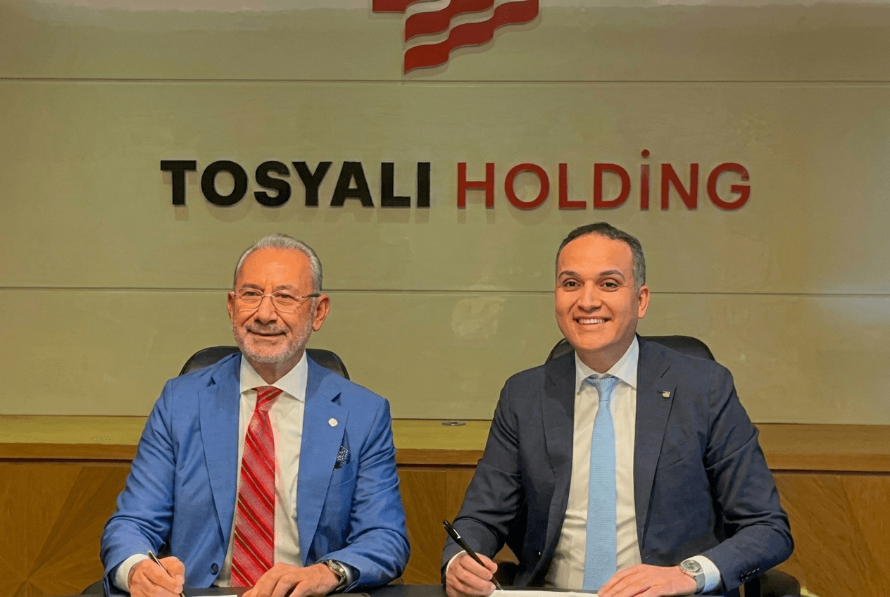 Two executives signing the Tosyali Holding green steel agreement for Benghazi under the company logo