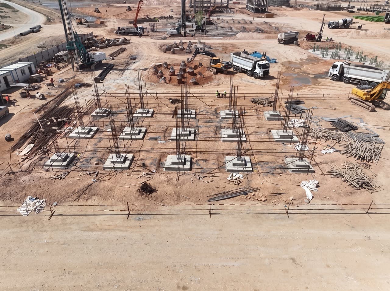 Aerial view of concrete column foundations, rebar, piling rigs and trucks at the Benghazi steel complex construction site