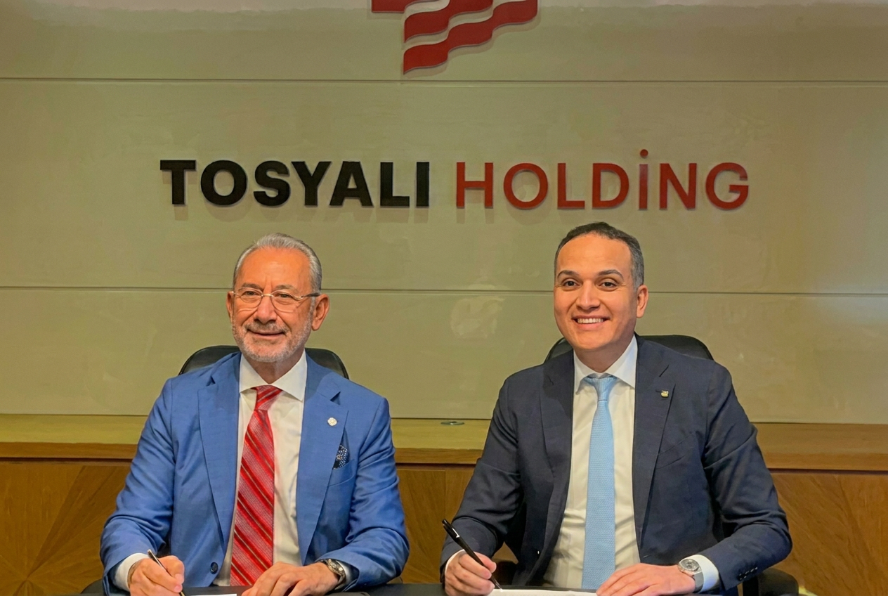 Two executives signing the Tosyali Holding green steel agreement for Benghazi under the company logo
